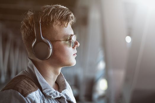 Portrait of a young stylish man listening to music with earphones . Lifestyle concept.