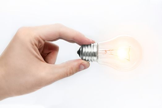 A man's hand holding a burning light bulb on a white background