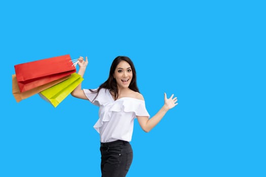 Beautiful asian young woman with shopping bags with smile while standing at the clothing store. Happiness, consumerism, sale and people concept
