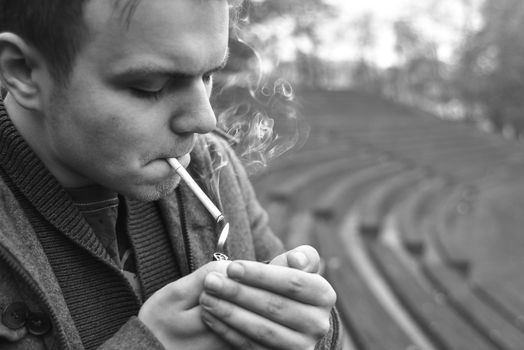 Guy smokes a cigarette outside, portrait, close-up