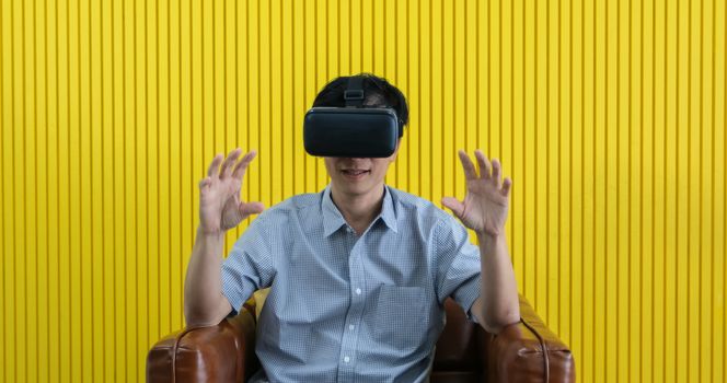 Senior Asian man using tablet and virtual reality simulator playing games in living room and feeling happy . Lifestyle Senior family at home concept.