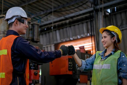 Technician or worker man and woman show greeting action for the successful of their work and they look happy in factory area.