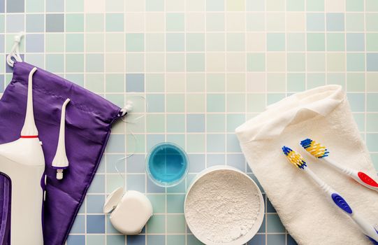 Oral hygiene, dental tools, dental floss, mouth irrigator, toothbrushes and tooth powder top view on blue background