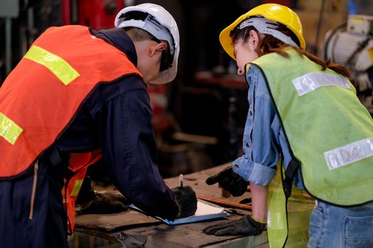 Technician or worker man and woman work together by discussion about their work in the factory with happy emotion.