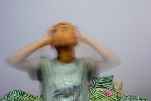 Young man facing anxiety clutching his head