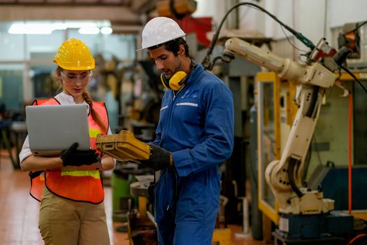 Technician or worker man and woman discussion about robot working in factory. Concept of good system and manager support for better industrial business.