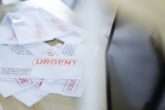 Debt letters that are collected on past overdue bills and final announcements on the table. Red writing to represent the struggle against economic unemployment.