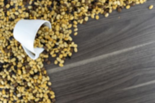 White coffee cup and raw coffee beans in the upper right corner, wooden floor