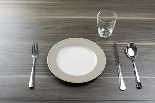 Spoon knives and empty dishes on a wooden table