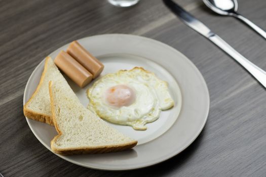 Breakfast on a white plate on the wooden floor