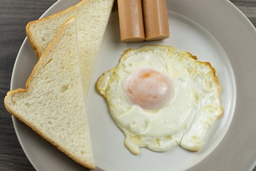 Breakfast on a white plate on the wooden floor