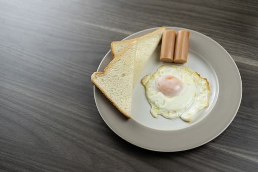 Breakfast on a white plate in the lower right corner on the wooden floor
