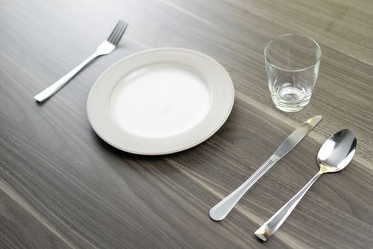 Spoon knives and empty dishes on a wooden table