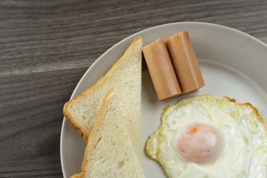 Breakfast on a white plate in the lower right corner on the wooden floor