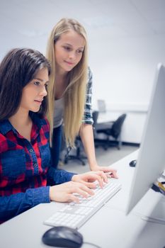 Smiling students using computer at university 