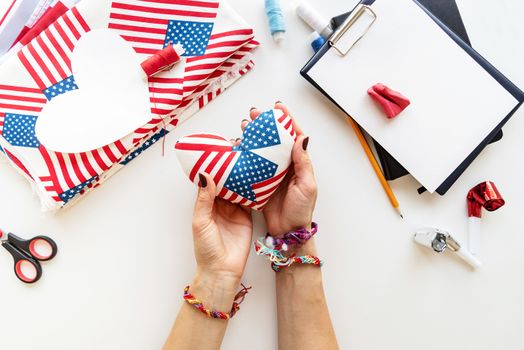 4th of July USA Independence Day pin cusion craft. Woman hands holding a needle holder colored into the US flag colors