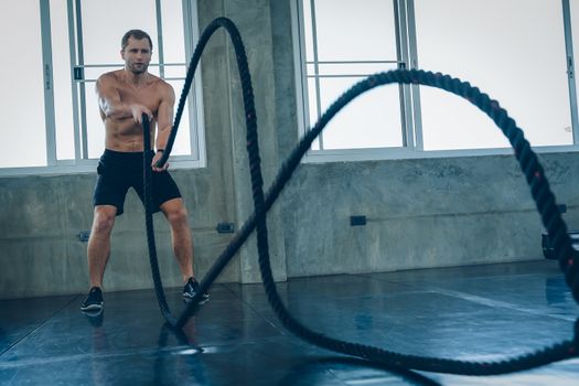 Strong man training with rope in functional training fitness in gym,Athlete builder muscles lifestyle.