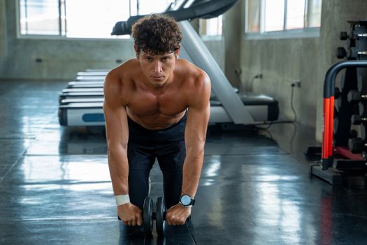 Athletic man exercising with fitness roller in gym club,Athlete builder muscles concept.