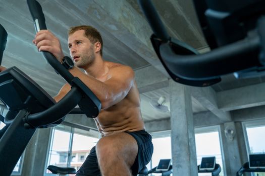 Man spinning an electric bicycle in the gym For good health and allowing the muscles to relax,Men workout activity concept.