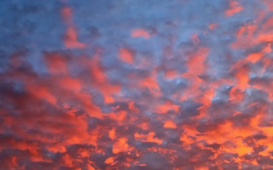 Beautiful panorama of orange and yellow clouds at sunrise and sunset in a blue sky