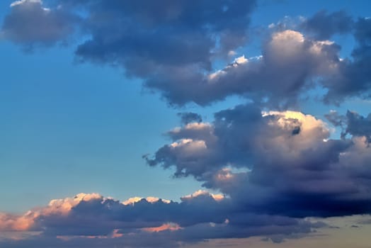 Beautiful panorama of orange and yellow clouds at sunrise and sunset in a blue sky