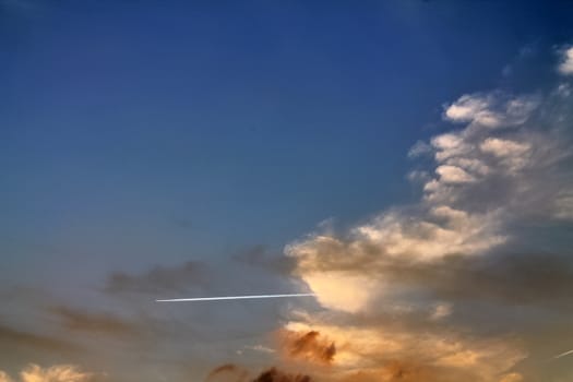 Beautiful panorama of orange and yellow clouds at sunrise and sunset in a blue sky