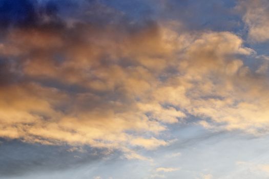 Beautiful panorama of orange and yellow clouds at sunrise and sunset in a blue sky