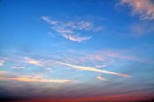 Beautiful panorama of orange and yellow clouds at sunrise and sunset in a blue sky