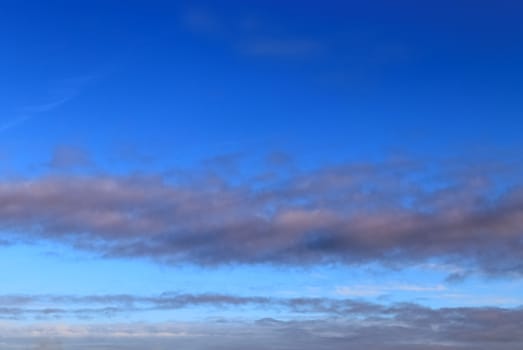 Beautiful panorama of orange and yellow clouds at sunrise and sunset in a blue sky