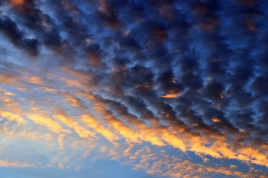 Beautiful panorama of orange and yellow clouds at sunrise and sunset in a blue sky