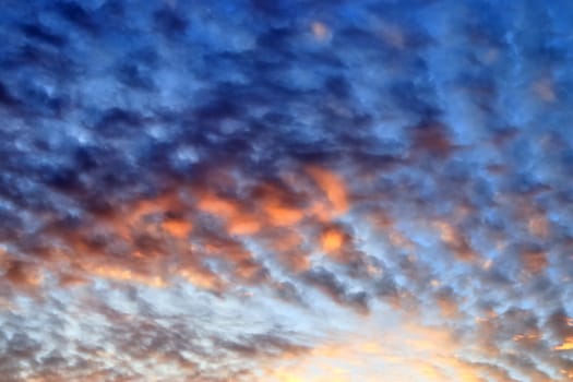 Beautiful panorama of orange and yellow clouds at sunrise and sunset in a blue sky