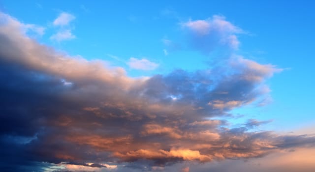 Beautiful panorama of orange and yellow clouds at sunrise and sunset in a blue sky