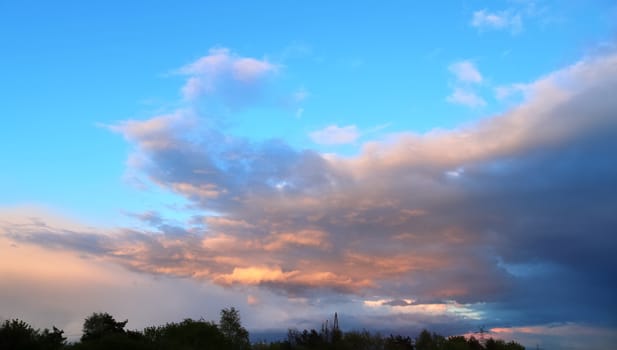 Beautiful panorama of orange and yellow clouds at sunrise and sunset in a blue sky