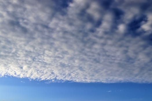 Beautiful panorama of orange and yellow clouds at sunrise and sunset in a blue sky