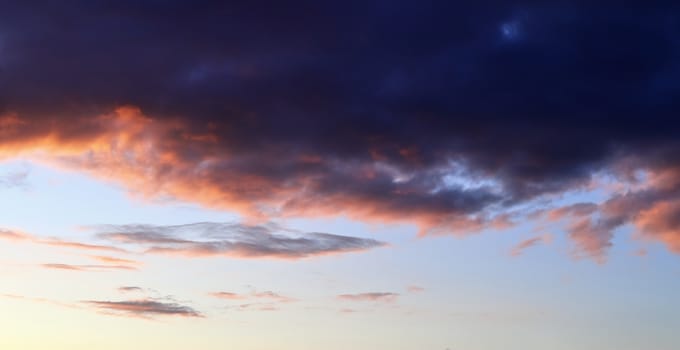 Beautiful panorama of orange and yellow clouds at sunrise and sunset in a blue sky