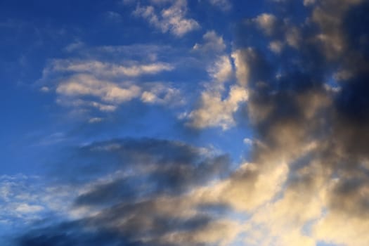 Beautiful panorama of orange and yellow clouds at sunrise and sunset in a blue sky