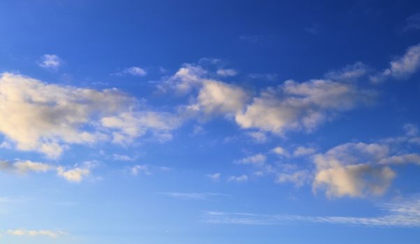 Beautiful panorama of orange and yellow clouds at sunrise and sunset in a blue sky