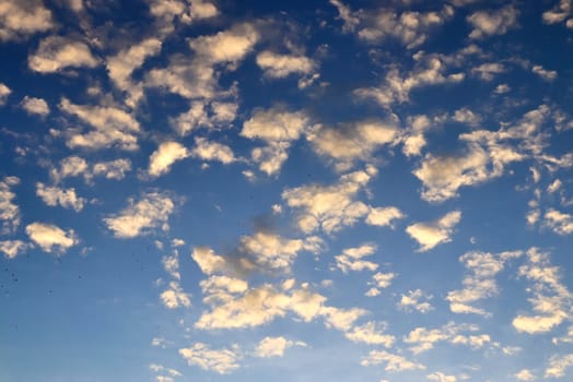 Beautiful panorama of orange and yellow clouds at sunrise and sunset in a blue sky