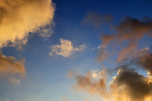 Beautiful panorama of orange and yellow clouds at sunrise and sunset in a blue sky