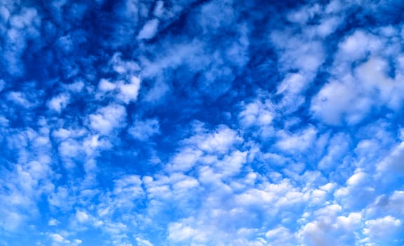 Beautiful panorama of orange and yellow clouds at sunrise and sunset in a blue sky