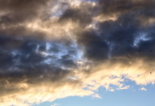 Beautiful panorama of orange and yellow clouds at sunrise and sunset in a blue sky