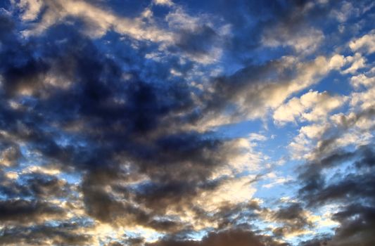 Beautiful panorama of orange and yellow clouds at sunrise and sunset in a blue sky