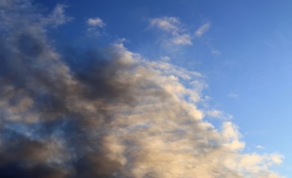 Beautiful panorama of orange and yellow clouds at sunrise and sunset in a blue sky