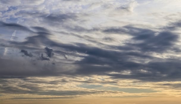 Beautiful panorama of orange and yellow clouds at sunrise and sunset in a blue sky