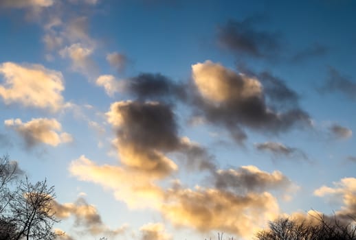 Beautiful panorama of orange and yellow clouds at sunrise and sunset in a blue sky