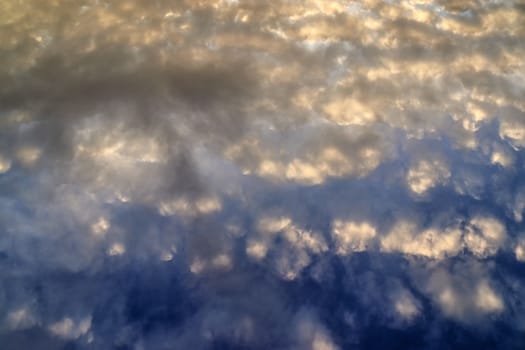 Beautiful panorama of orange and yellow clouds at sunrise and sunset in a blue sky