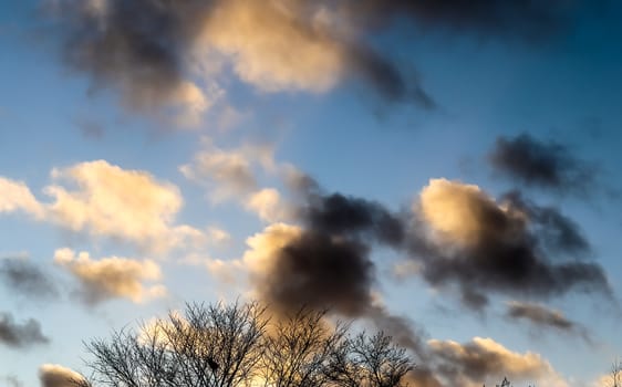 Beautiful panorama of orange and yellow clouds at sunrise and sunset in a blue sky