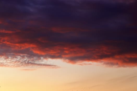 Beautiful panorama of orange and yellow clouds at sunrise and sunset in a blue sky