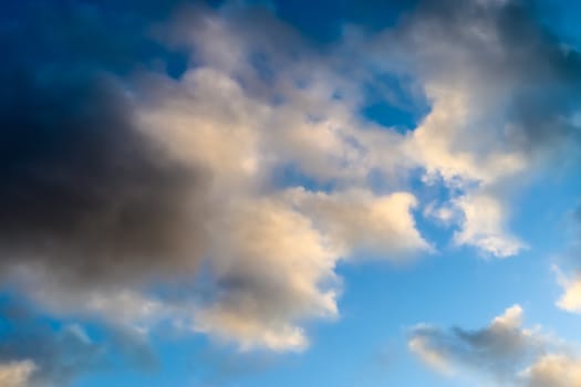 Beautiful panorama of orange and yellow clouds at sunrise and sunset in a blue sky