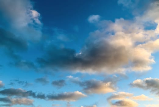 Beautiful panorama of orange and yellow clouds at sunrise and sunset in a blue sky